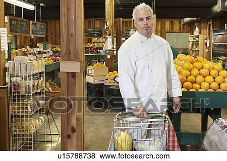 Stock Photo - Portrait of a mid adult chef with shopping cart in farmer's market. Fotosearch