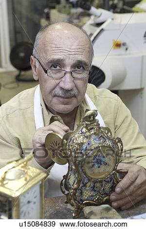 Stock Photo - Portrait of a skilled mature man repairing watch in workshop. Fotosearch