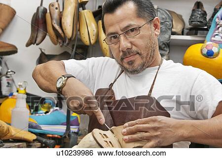 Portrait of a skilled shoemaker cutting shoe sole View Large Photo Image Stock Photograph - Portrait of a skilled shoemaker cutting shoe sole. Fotosearch