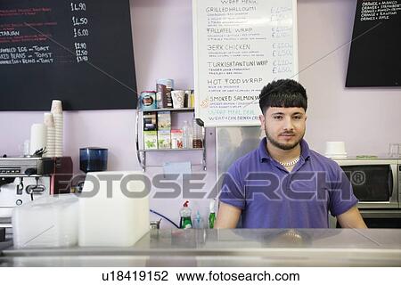 Portrait of a young man working in cafe View Large Photo Image Stock Image - Portrait of a young man working in cafe. Fotosearch