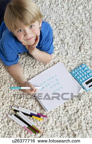 Portrait of blond hair boy lying on rug doing homework View Large Photo Image Stock Photograph - Portrait of blond hair boy lying on rug doing homework. Fotosearch