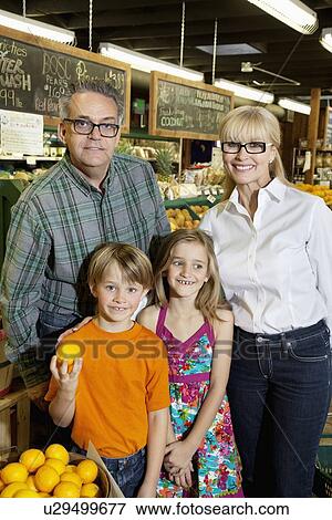 Stock Photo - Portrait of happy children with grandparents in produce market. Fotosearch