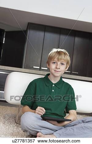 Portrait of pre-teen boy using tablet pc at home View Large Photo Image Stock Photo - Portrait of pre-teen boy using tablet pc at home. Fotosearch