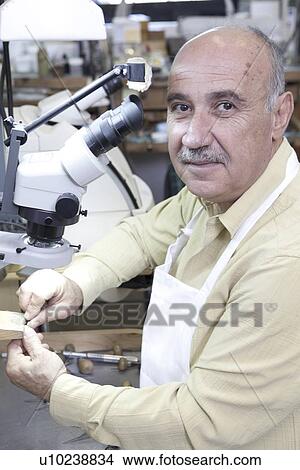 Portrait of skilled mature man with microscope in jewelry repair shop View Large Photo Image Picture - Portrait of skilled mature man with microscope in jewelry repair shop. Fotosearch