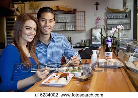 Portrait of young couple eating Japanese cuisine in restaurant View Large Photo Image Stock Image - Portrait of young couple eating Japanese cuisine in restaurant. Fotosearch