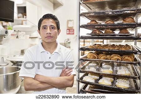 Portrait of young male baker with arms crossed in bakery View Large Photo Image Stock Image - Portrait of young male baker with arms crossed in bakery. Fotosearch