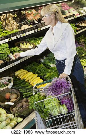 Senior woman shopping for vegetables in market View Large Photo Image Stock Image - Senior woman shopping for vegetables in market. Fotosearch