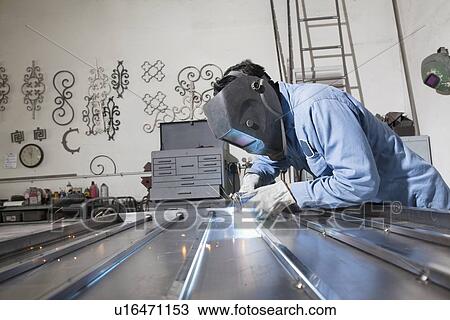 Side view of a young construction worker welding in workshop View Large Photo Image Stock Image - Side view of a young construction worker welding in workshop. Fotosearch