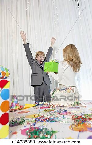 Sister giving gift to surprised birthday boy with arms raised View Large Photo Image Stock Image - Sister giving gift to surprised birthday boy with arms raised. Fotosearch