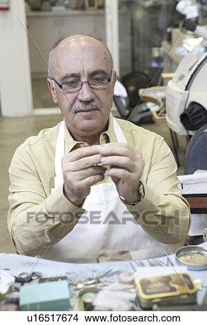 Skilled mature man repairing watch in workshop View Large Photo Image Picture - Skilled mature man repairing watch in workshop. Fotosearch