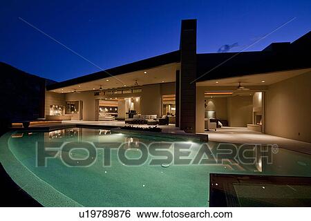 Stock Photograph - Swimming pool in front of luxury residential house. Fotosearch