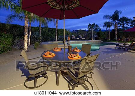 Table and chair under sunshade at poolside in manor house View Large Photo Image Picture - Table and chair under sunshade at poolside in manor house. Fotosearch