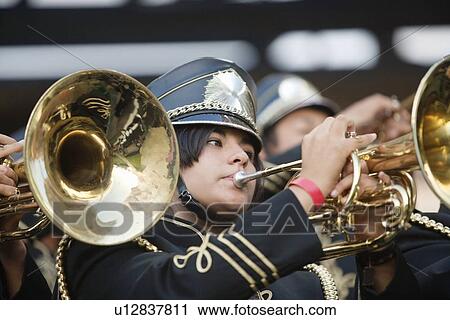 Stock Image - Teenage girl playing horn player in marching band. Fotosearch