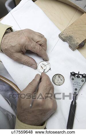 Top view of a mature worker repairing watch View Large Photo Image Stock Photo - Top view of a mature worker repairing watch. Fotosearch