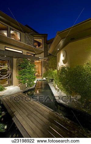 Stock Image - Wooden walkway leading towards manor house. Fotosearch