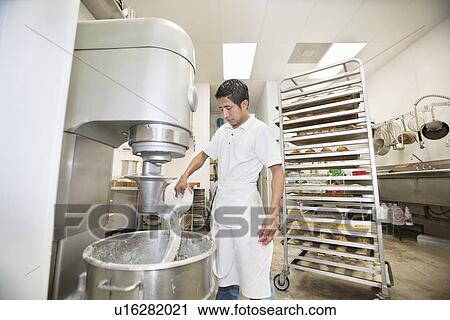 Young baker pouring flour in mixing bowl View Large Photo Image Stock Image - Young baker pouring flour in mixing bowl. Fotosearch