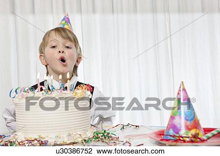 Young birthday boy blowing candles on cake View Large Photo Image Stock Image - Young birthday boy blowing candles on cake. Fotosearch