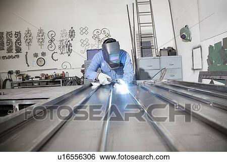 Young male worker welding in metal workshop View Large Photo Image Stock Photograph - Young male worker welding in metal workshop. Fotosearch