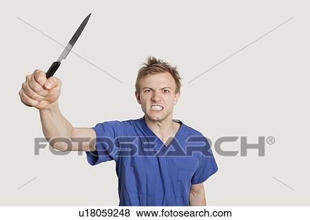 Angry male nurse threatening with knife over colored background View Large Photo Image Stock Photo - Angry male nurse threatening with knife over colored background. Fotosearch