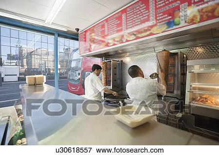 Back view of men working in kebab shop together View Large Photo Image Stock Photo - Back view of men working in kebab shop together. Fotosearch