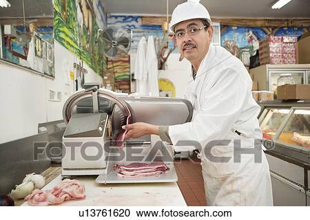 Butcher looking away while meat coming out of fly wheel slicer View Large Photo Image Stock Image - Butcher looking away while meat coming out of fly wheel slicer. Fotosearch