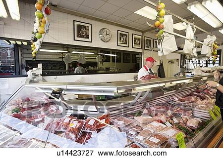 Butcher with processed meat in display case View Large Photo Image Stock Photo - Butcher with processed meat in display case. Fotosearch