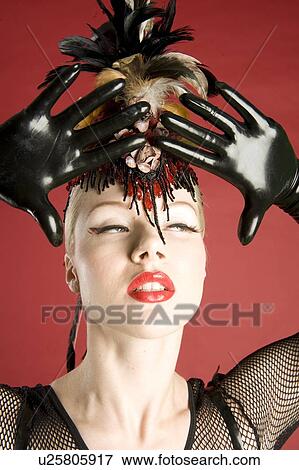 Close-up of beautiful young woman wearing feather headwear and leather gloves looking away View Large Photo Image Stock Photo - Close-up of beautiful young woman wearing feather headwear and leather gloves looking away. Fotosearch