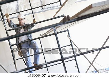 Construction worker climbing up the scaffold View Large Photo Image Stock Photo - Construction worker climbing up the scaffold. Fotosearch