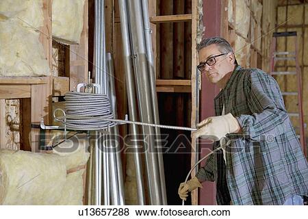 Construction worker pulling iron cable View Large Photo Image Stock Photo - Construction worker pulling iron cable. Fotosearch