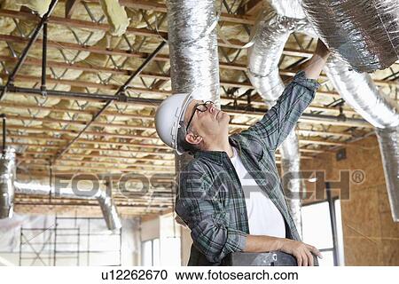 Construction worker working on unfinished ceiling View Large Photo Image Stock Image - Construction worker working on unfinished ceiling. Fotosearch