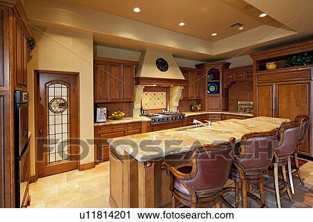 Stock Image - Contemporary kitchen counter with chair in luxury manor house. Fotosearch