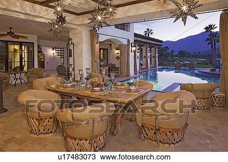 Stock Image - Dining room with contemporary lighting fixture in mansion. Fotosearch