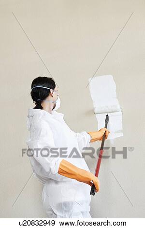 Female worker in protective workwear painting wall View Large Photo Image Stock Photo - Female worker in protective workwear painting wall. Fotosearch