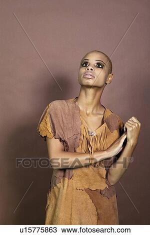 Stock Image - Front view of an African American woman looking up over colored background. Fotosearch