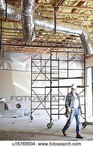 Picture - Front view of contractor walking at construction site. Fotosearch