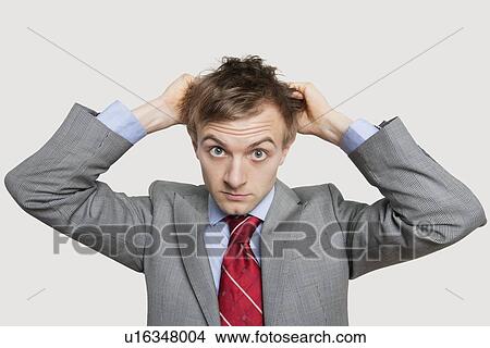 Front view of young businessman in confusion scratching head over colored background View Large Photo Image Picture - Front view of young businessman in confusion scratching head over colored background. Fotosearch
