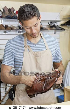 Front view of young shoemaker with handmade shoes View Large Photo Image Picture - Front view of young shoemaker with handmade shoes. Fotosearch