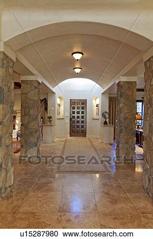 Stock Image - Hallway leading to a door in luxury villa. Fotosearch
