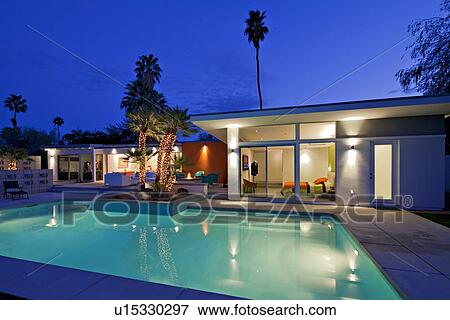 Stock Photo - Illuminated swimming pool and villa at night. Fotosearch
