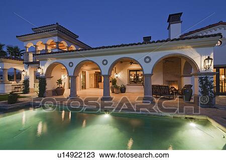Illuminated swimming pool of luxury mansion View Large Photo Image Stock Image - Illuminated swimming pool of luxury mansion. Fotosearch