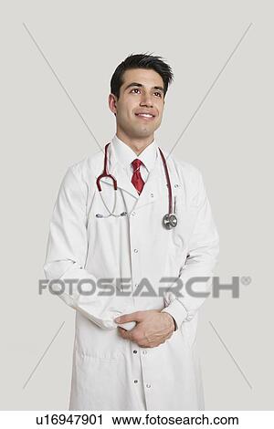 Indian male doctor looking away over gray background View Large Photo Image Stock Image - Indian male doctor looking away over gray background. Fotosearch