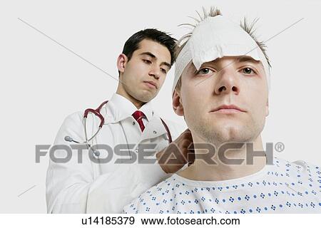 Indian male doctor treating male patient View Large Photo Image Stock Photo - Indian male doctor treating male patient. Fotosearch