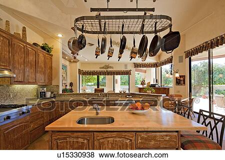 Stock Photo - Kitchen counter with utensils hanging in luxury villa. Fotosearch