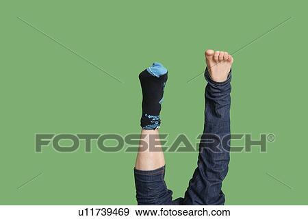 Low section of man's feet with sock in one leg over colored background View Large Photo Image Stock Photo - Low section of man's feet with sock in one leg over colored background. Fotosearch