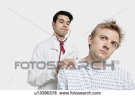 Male patient being examined by an Indian doctor View Large Photo Image Stock Photo - Male patient being examined by an Indian doctor. Fotosearch