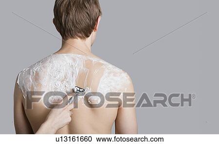 Man getting his back shaved over colored background View Large Photo Image Stock Image - Man getting his back shaved over colored background. Fotosearch