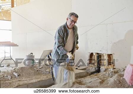 Mature man with shovel working at construction site View Large Photo Image Stock Photo - Mature man with shovel working at construction site. Fotosearch