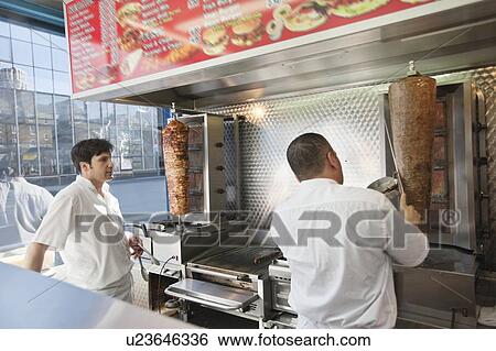 Stock Photograph - mid adult men working in fast food shop. Fotosearch