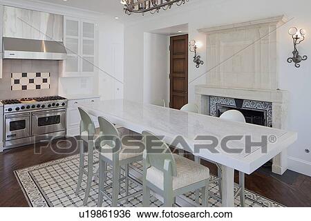 Stock Photograph - Modern kitchen with dining table and chair in luxury villa. Fotosearch