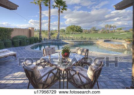 Stock Photo - Outdoors table and chair in patio of mansion. Fotosearch